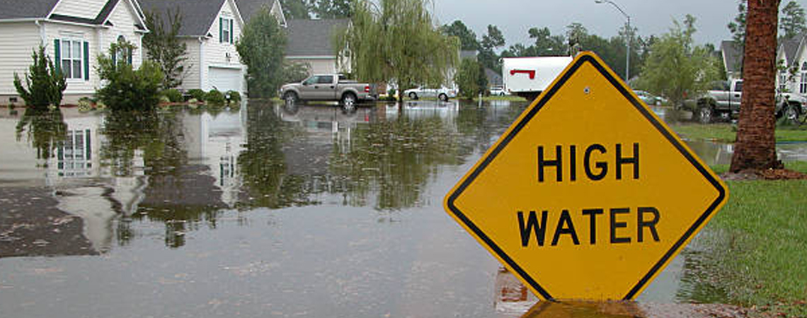 High Water Warning Sign on Flooded Street